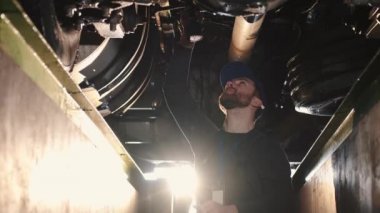 Otomatik tamirci alttaki kamyon süspansiyonunu tamir etti