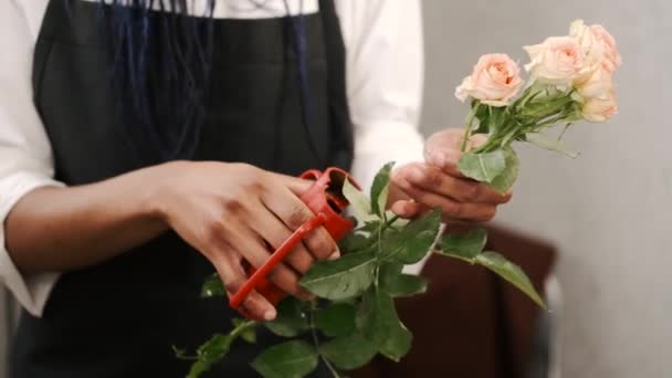 Female florist in glasses arranging bouquet and cutting roses with pruner in flower shop — Stock Video