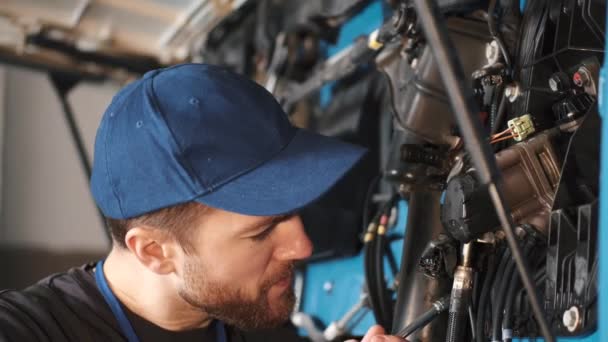 Профессиональный автомеханик проверяет грузовой двигатель в гараже — стоковое видео