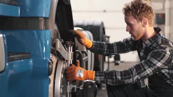 車のサービスでトラックタイヤを修理する車の整備士 — ストック動画