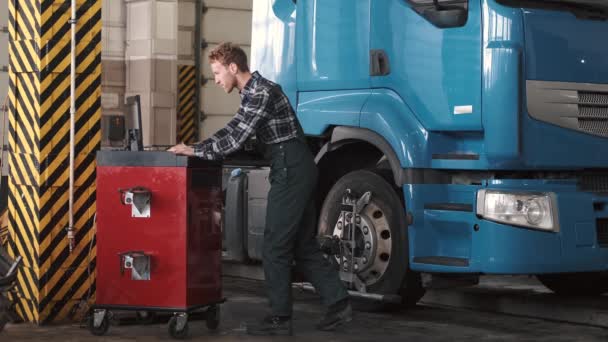 Mechanic using laptop near car engine compartment — Stock Video