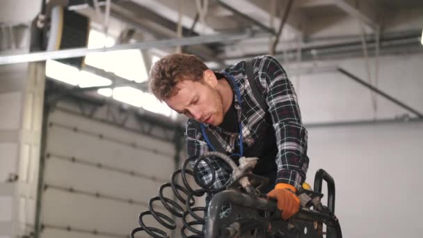Joven mecánico reparando un camión en taller de reparación de automóviles — Vídeos de Stock