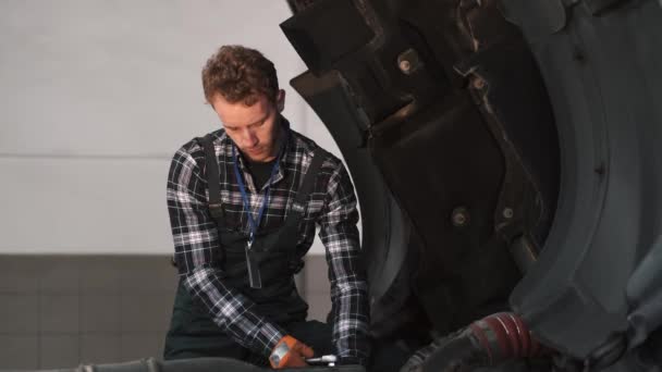 Young mechanic repairing a truck in auto repair shop — Stock Video
