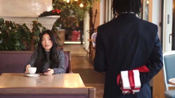 Hombre africano haciendo sorpresa para su novia el día de San Valentín en el restaurante — Vídeos de Stock