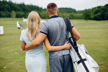 Golf sahasında golf oynayan güzel bir çift.