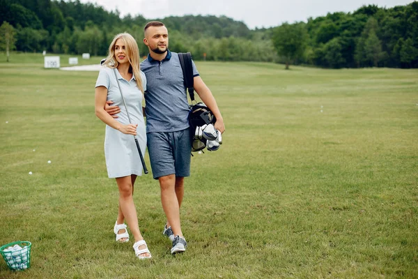 Vakkert par som spiller golf på en golfbane – stockfoto