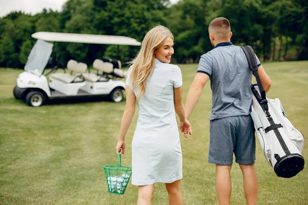 Piękna para grająca w golfa na polu golfowym — Zdjęcie stockowe