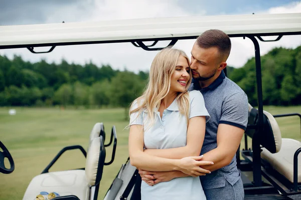Schönes Paar beim Golfspielen auf einem Golfplatz — Stockfoto
