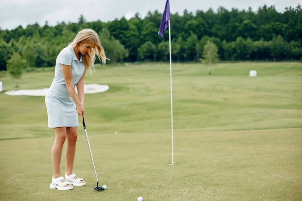 Gyönyörű lány golfozik egy golfpályán. — Stock Fotó