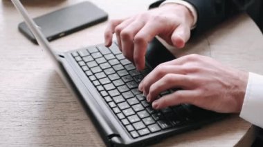 Laptop ve kağıtlarla bir kafede çalışan odaklanmış bir işadamı.