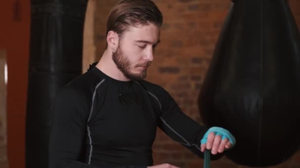 Boxer is putting boxers gloves on his hands preparing to spar — Stock Video