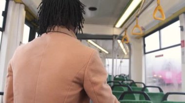 Kamu otobüsündeki Afrikalı adamın arka görüntüsü.