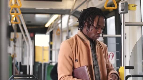 Afro-Américain en vêtements caduques utiliser le téléphone dans les transports publics — Video