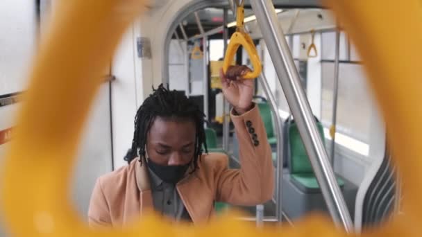 Африканський американець у трудовому одязі користується телефоном у громадському транспорті. — стокове відео