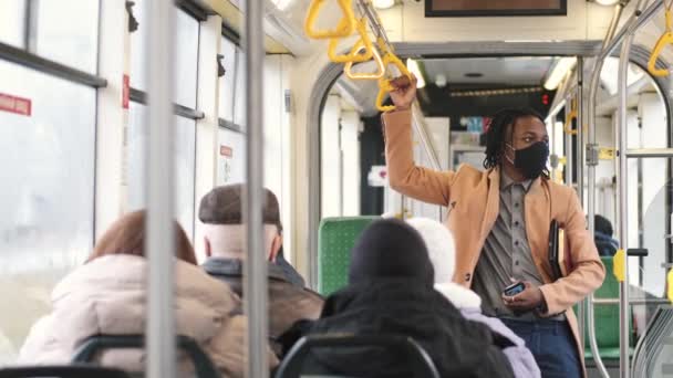 Estudante afro-americano mascarado usando transporte público — Vídeo de Stock