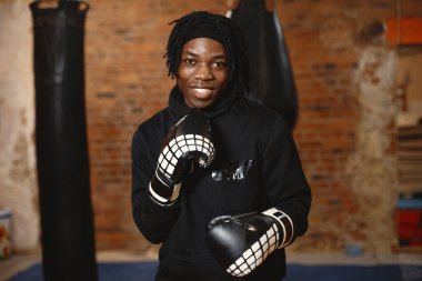 Spor salonunda siyah eldivenli Afrikalı erkek boksör.