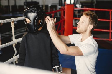 Boks eldivenli küçük çocuk antrenörüyle ringde.