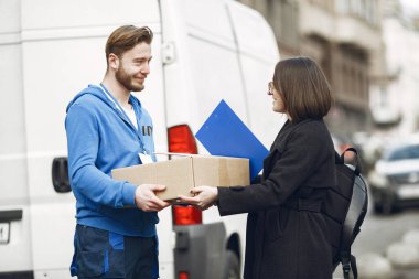 Erkek, kadın müşteriye bir paket verir.