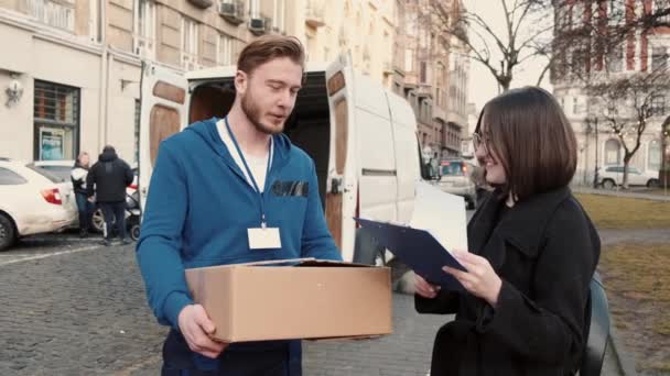 Levering man het geven van pakket naar gelukkig vrouwelijke klant outdoor — Stockvideo