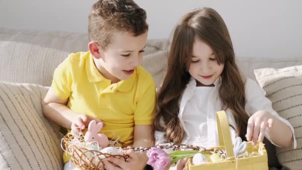 Kids playing with Eastern toys in basket sitting on coach — Stock Video