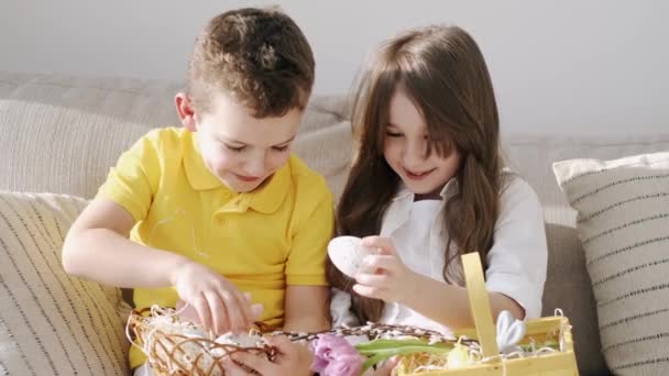 Kids playing with Eastern toys in basket sitting on coach — Stock Video