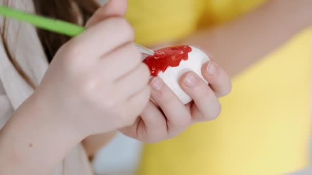 Mãe colorindo ovos de Páscoa com seus filhos na sala branca — Vídeo de Stock