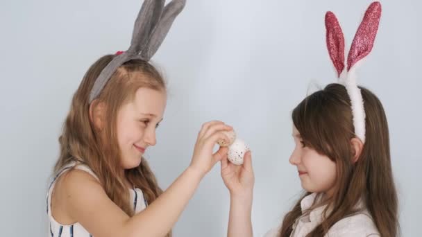 Dos amigas en orejas de conejo sosteniendo huevos de Pascua en vacaciones — Vídeo de stock