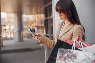 Şehirde alışveriş çantalı bir kadın.