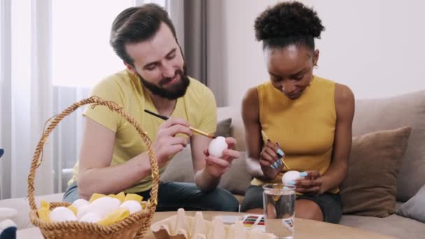 Mujer negra y hombre europeo pintando huevos de Pascua juntos — Vídeos de Stock