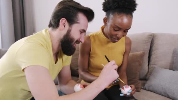 Mulher negra e homem europeu pintando ovos de Páscoa juntos — Vídeo de Stock