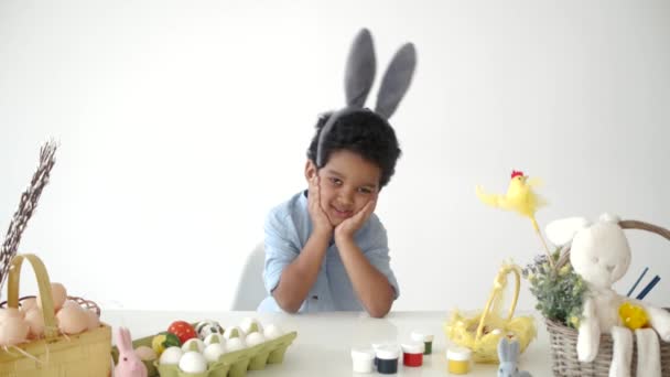 Słodkie mało afrykański chłopiec siedzi przy stole w śmieszne uszy — Wideo stockowe