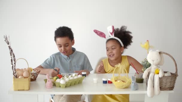 Τα παιδιά ζωγραφίζουν μαζί το Πάσχα σε ένα λευκό δωμάτιο — Αρχείο Βίντεο
