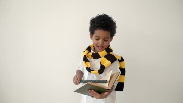 Afrikai amerikai gyerek olvas egy könyvet, és kezében varázspálca — Stock videók
