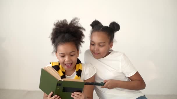 African american girls reading a book and holding magic wand