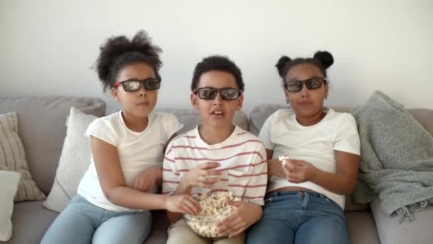 Niedliche Kinder in 3D-Brille sehen Film auf der Couch — Stockvideo