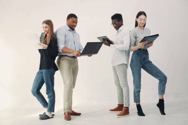 Genç uluslararası insanlar birlikte çalışıyor ve bilgisayarı kullanıyorlar.