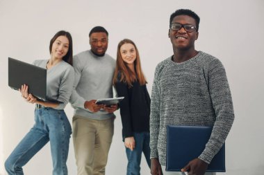 Genç uluslararası insanlar birlikte çalışıyor ve bilgisayarı kullanıyorlar.