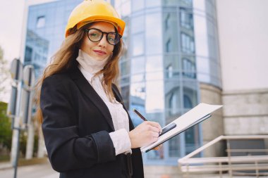 Arkasında inşaat alanı olan kadın mimar