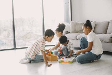 Çocuklar yerde renkli bir inşaatçıyla oynuyorlar.