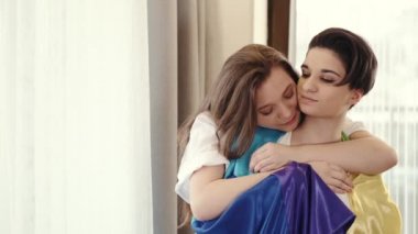 Evde bayraklı homoseksüel çift sarılıyor.
