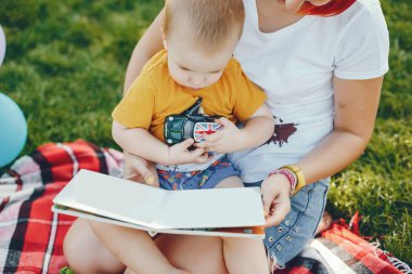 Anne ve oğlu yaz parkında oynuyorlar.