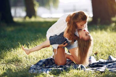 Anne ve kızı yaz parkında oynuyorlar.