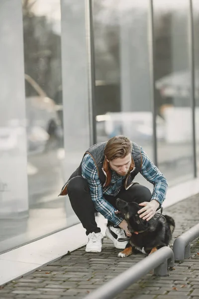 Man with a dog in a city — стоковое фото