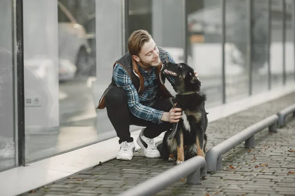 Man with a dog in a city — Stock Photo, Image