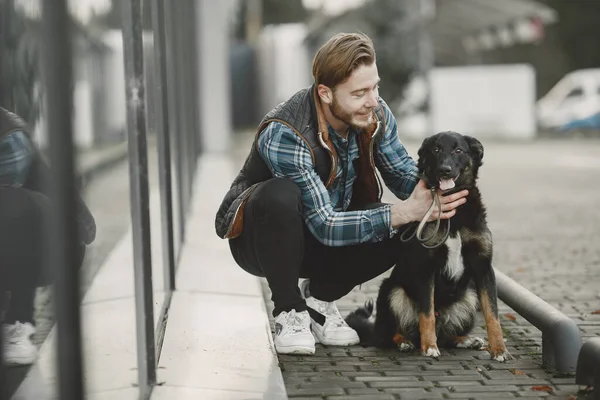 Man with a dog in a city — стоковое фото