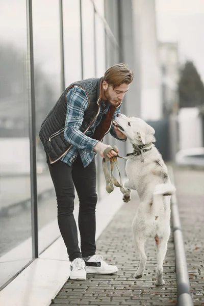 Man with a dog in a city — стоковое фото