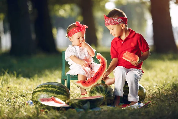 Cute little children with watermelons in a park — Stok fotoğraf