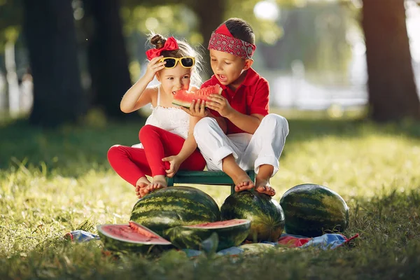 Cute little children with watermelons in a park — Zdjęcie stockowe