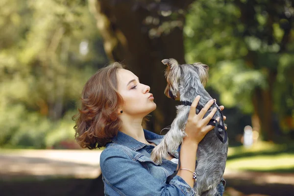 Roztomilé dívka v modré bundě hrát s malým psem — Stock fotografie