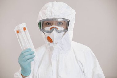 Koruyucu giysili kadın Corona virüsü aşısını elinde tutuyor.